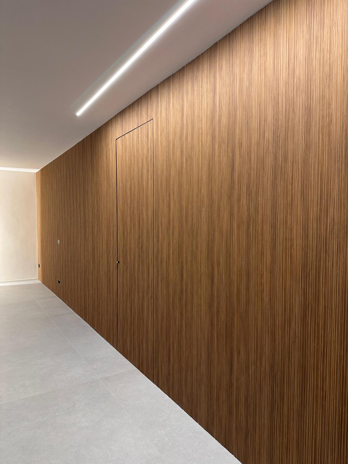 Boiserie Déco Moove Golden finitura teak con porta rasoparete in un salone a Cittadella