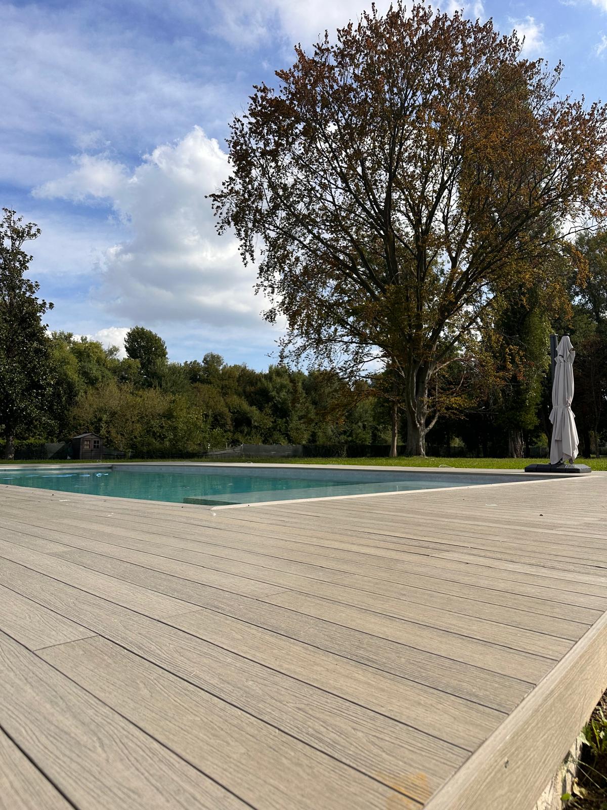 Dettaglio delle doghe WPC che raccordano piscina e giardino nel Padovano