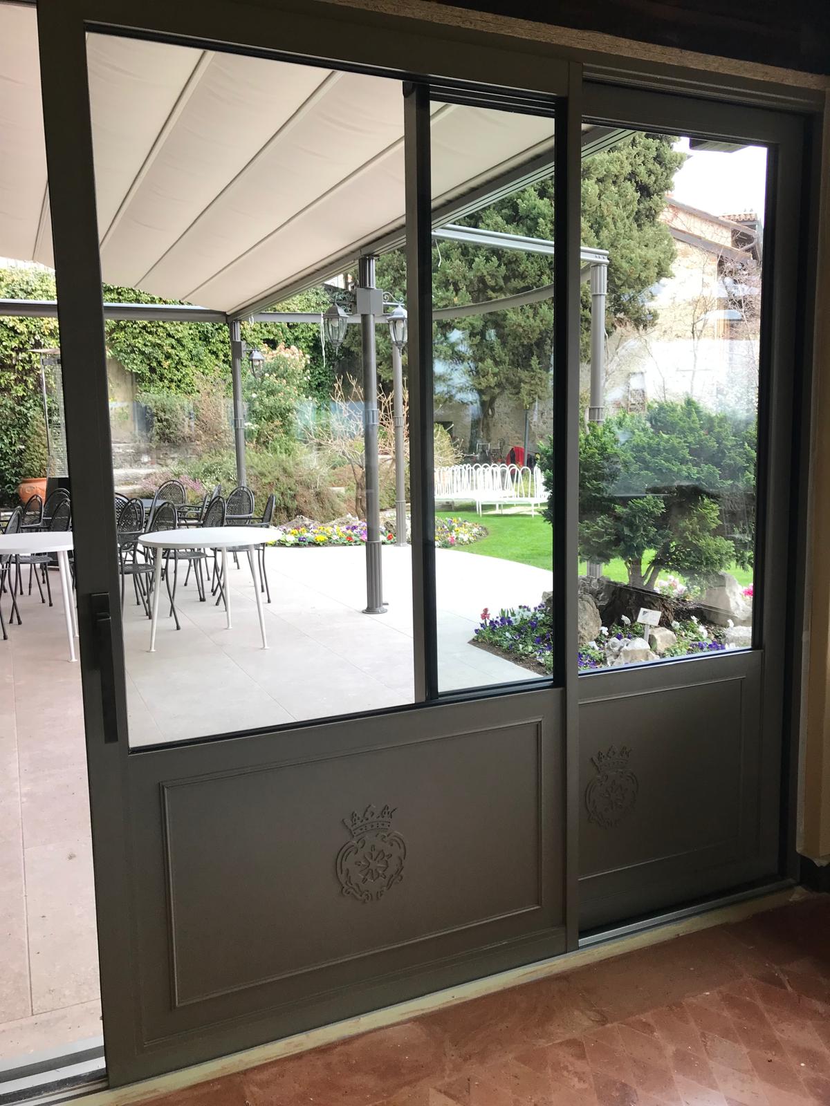 Serramento scorrevole in alluminio grigio scuro affacciato sul giardino di una casa ad Asolo