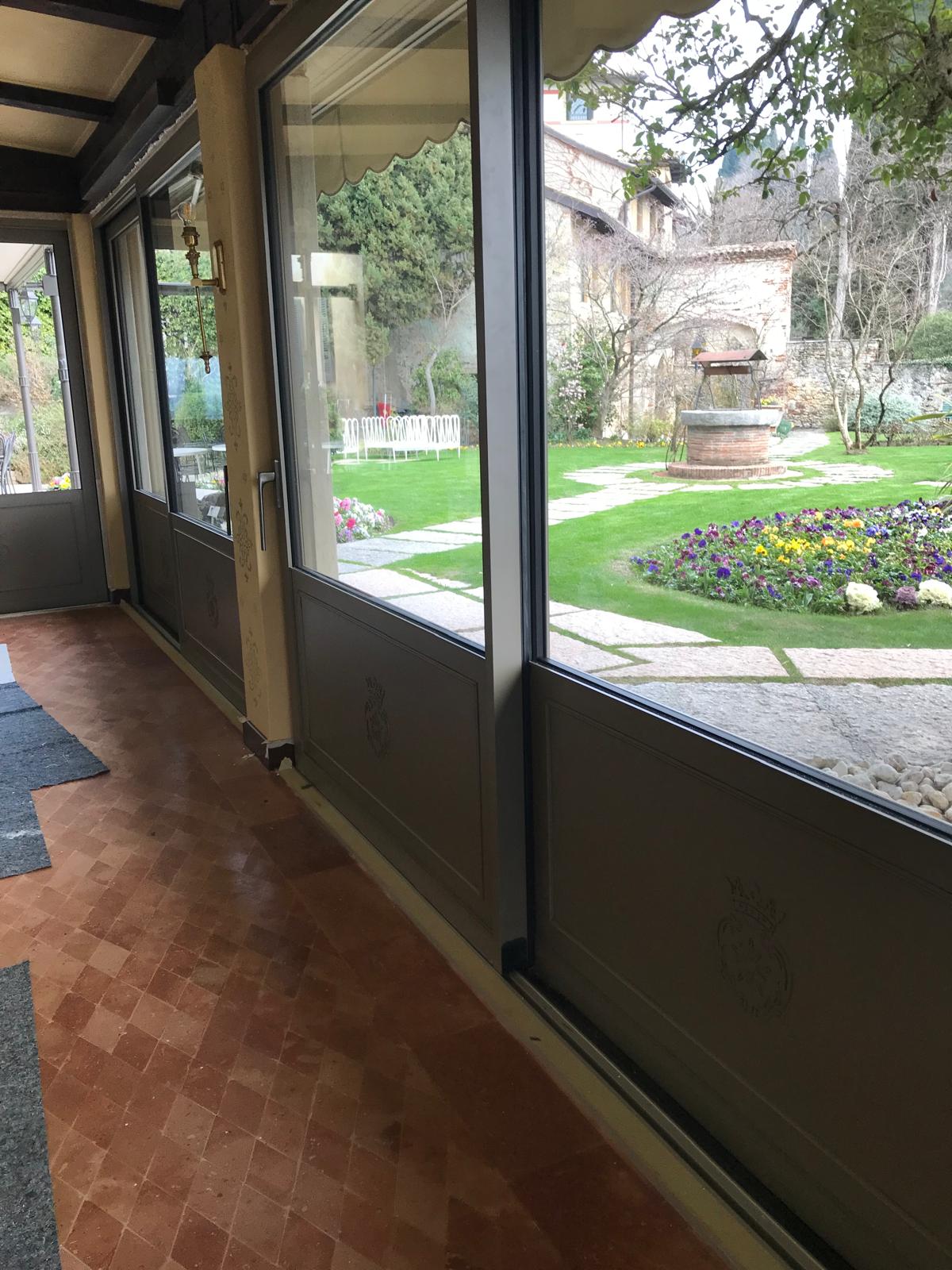 Vista interna di serramenti scorrevoli in alluminio grigio scuro in una residenza ad Asolo