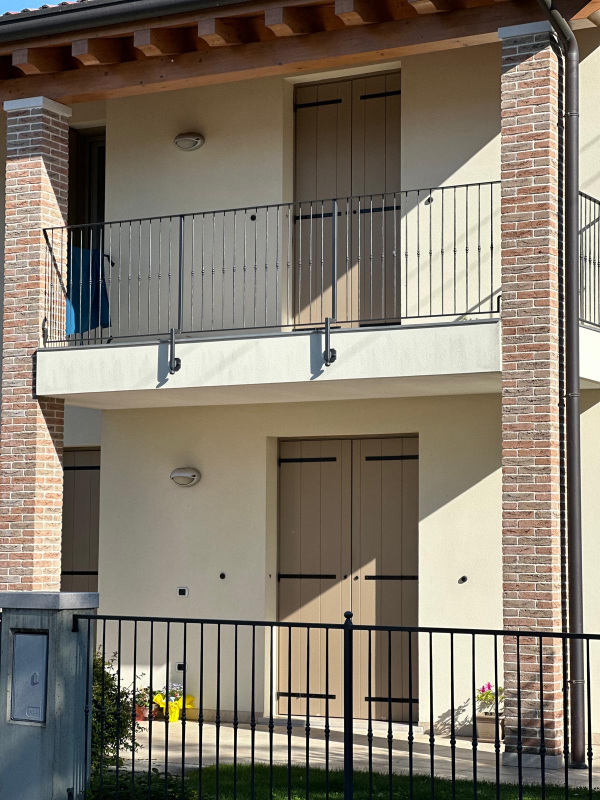 Balcone in alluminio scuro davanti al portico di una casa a Treviso