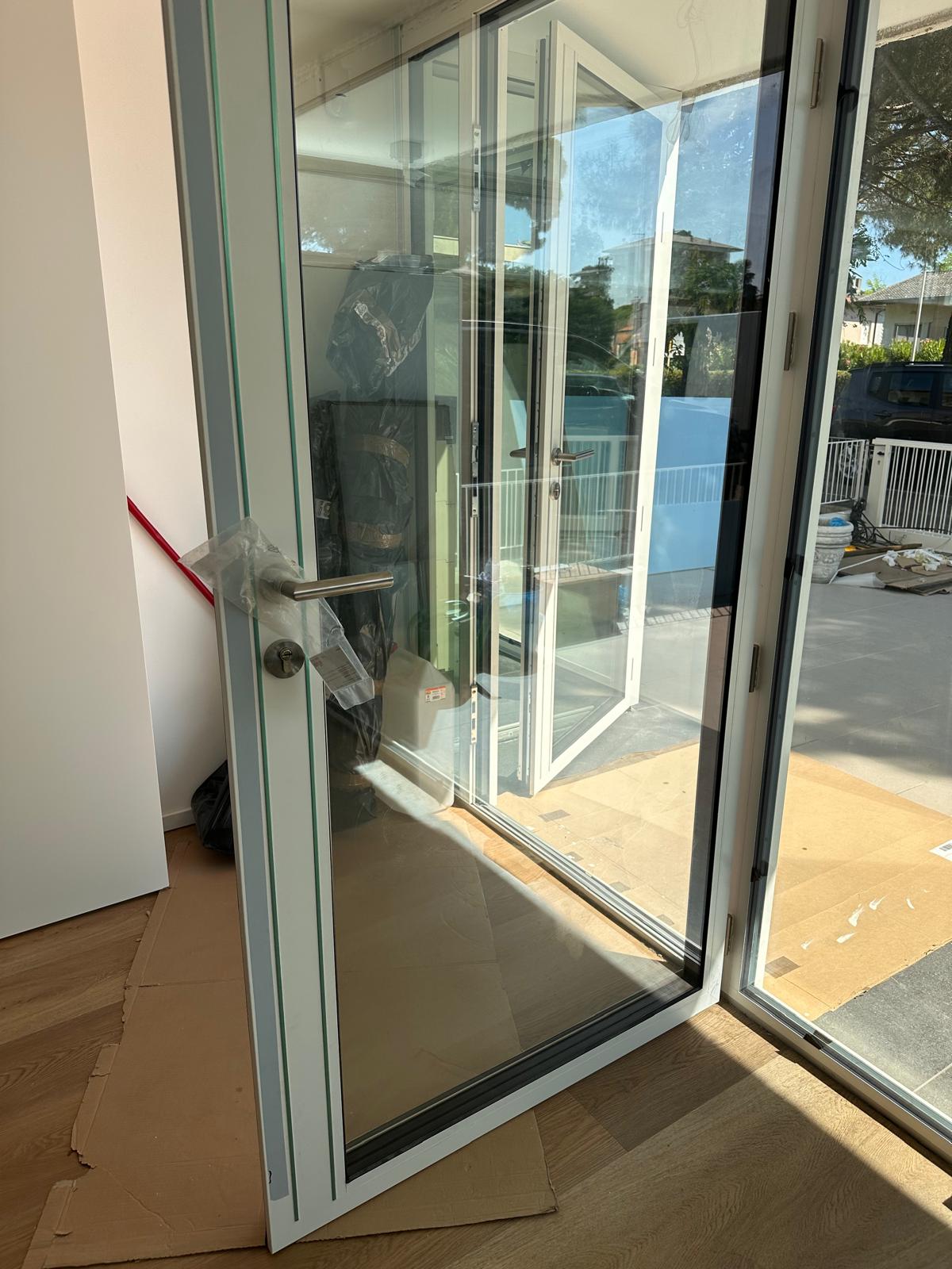 Porta vetrata in alluminio aperta durante il cantiere a Caorle